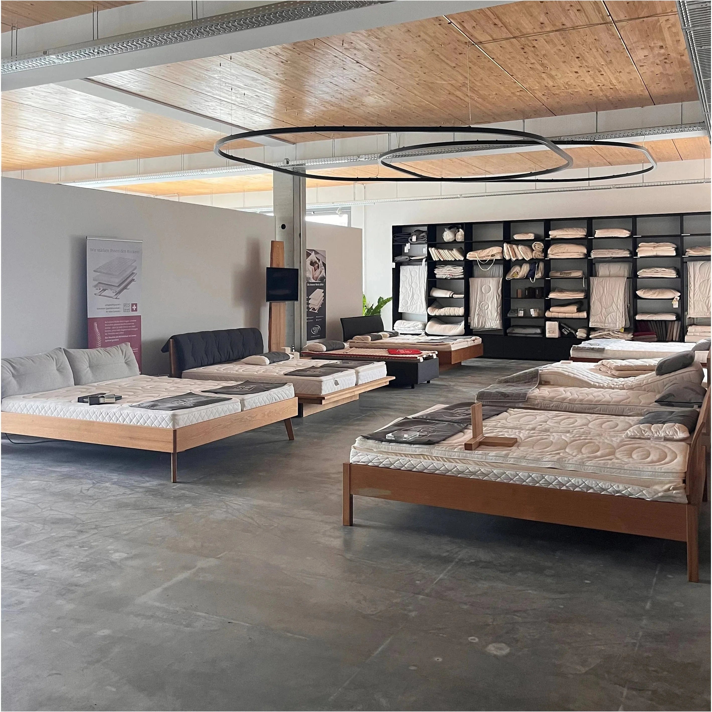 Einblick in das Bettengeschäft der Holzmanufaktur Nähe Stuttgart und Ludwigsburg. Massivholzbetten und Bio Matratzen in großer Auswahl zum Probe liegen.