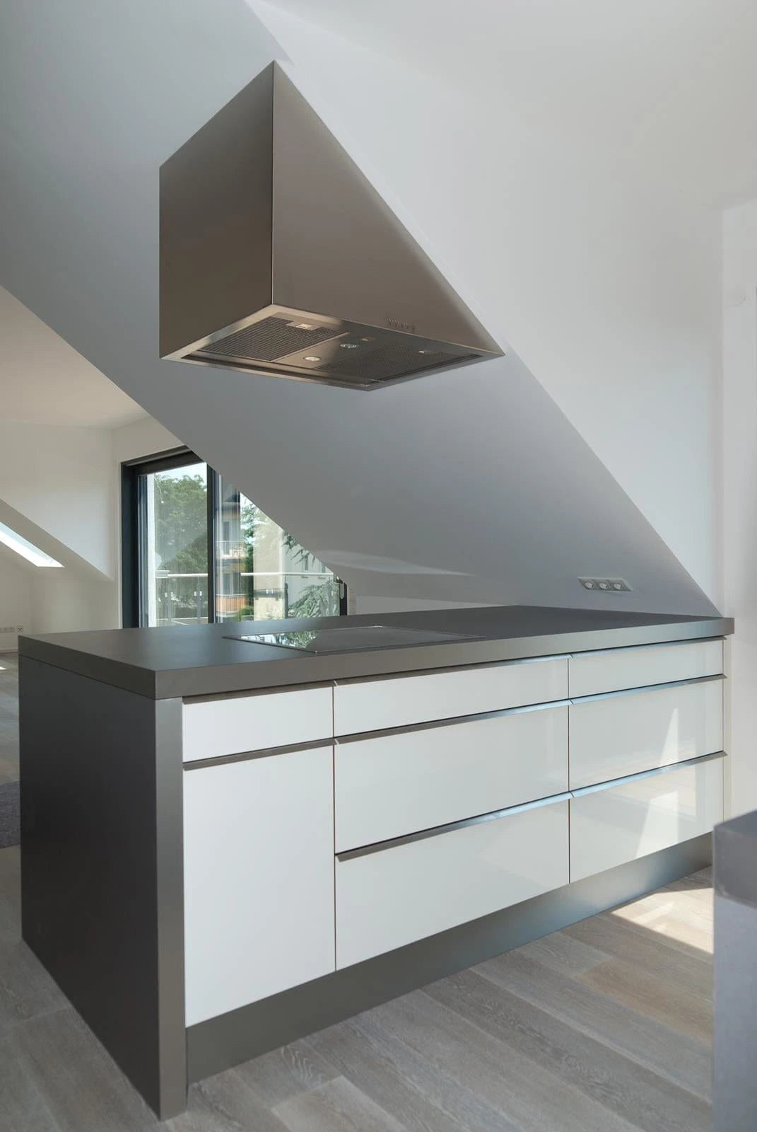 Moderne Kochinsel Küche in der Dachschräge, mit speziellem Dunstabzug eingebaut.