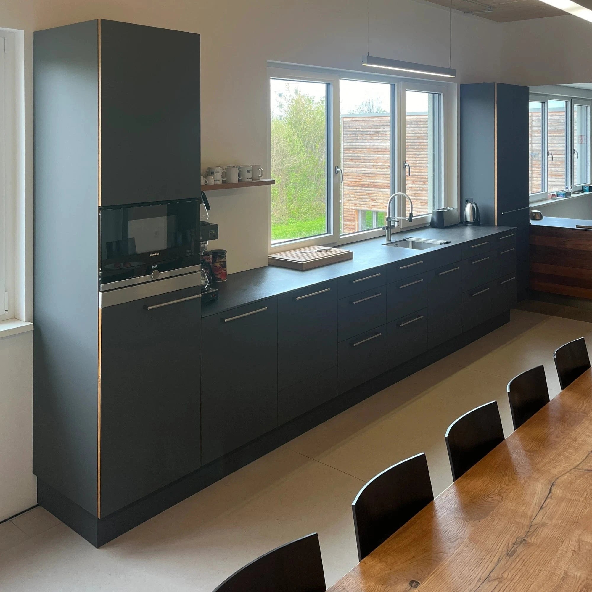 Küchen Design in der Küchenausstellung, auch für eine schwarze Mitarbeiter-Küche mit Holzkanten aus Eiche.