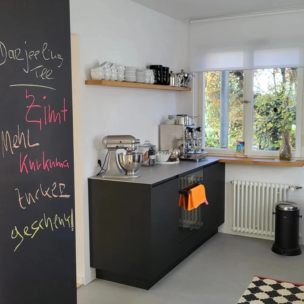 Schwarze kleine Küchenzeile auf kleinstem Raum, mit einem Regal aus massivem Holz kombiniert