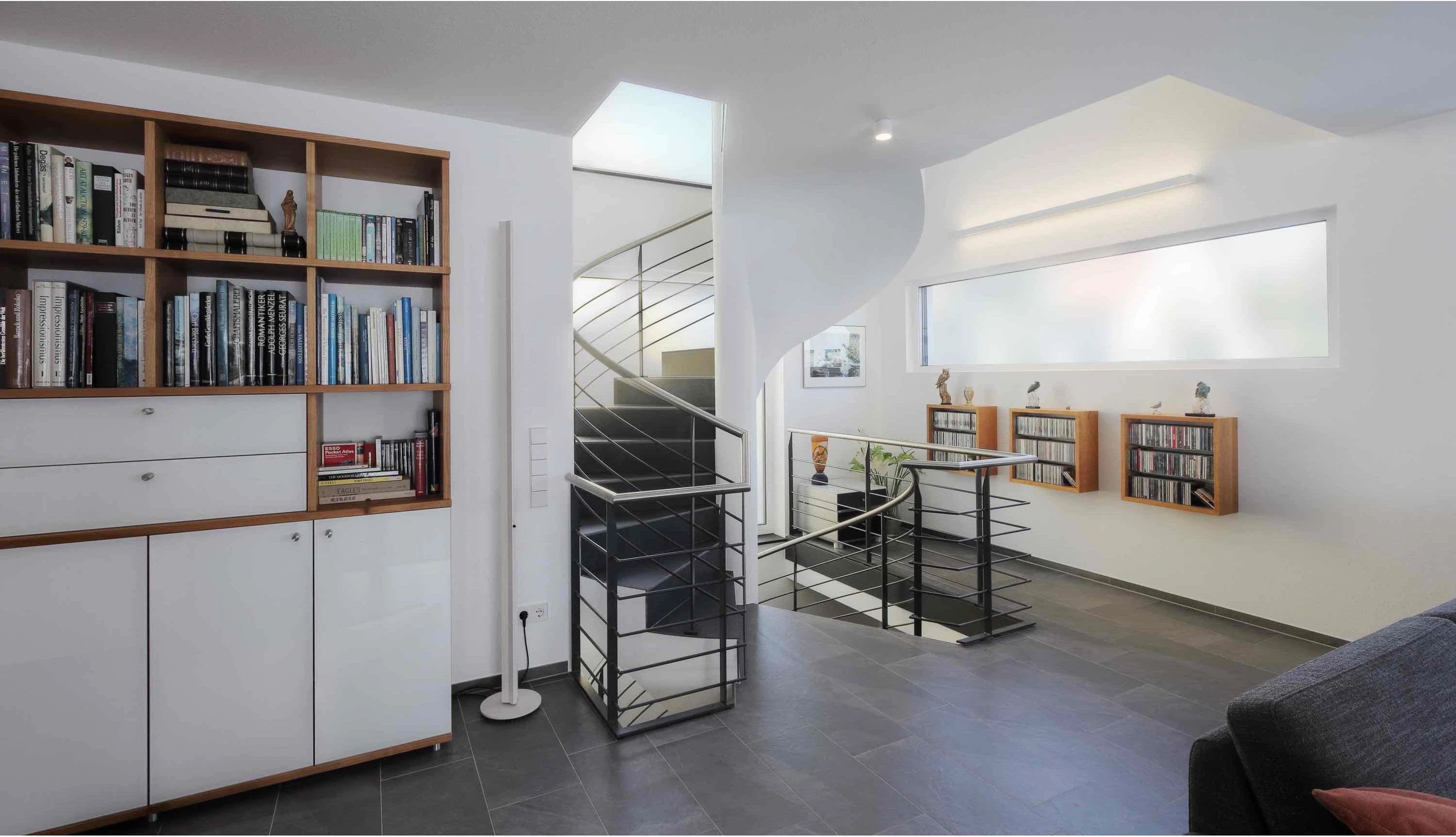 Großes Bücherregal und Hängeregale aus massiver Kernbuche aus unserer Schreinerei, unten kombiniert mit einer weißen Front.