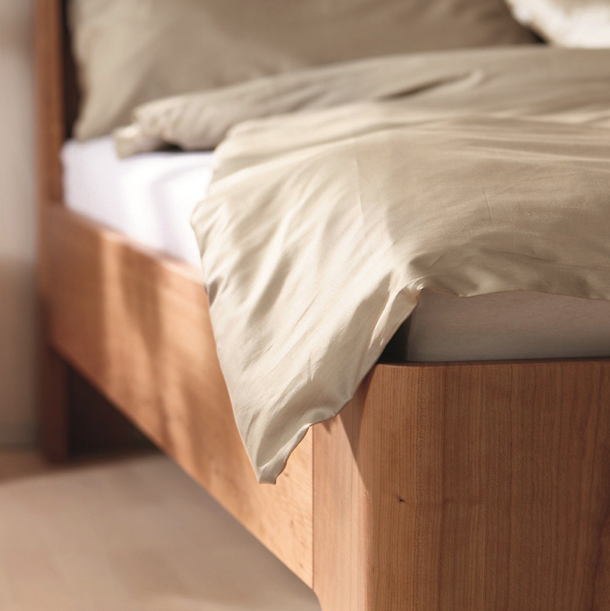 Fußteil-Detail vom Bett GIRO mit Komforthöhe in massivem Kirschbaum