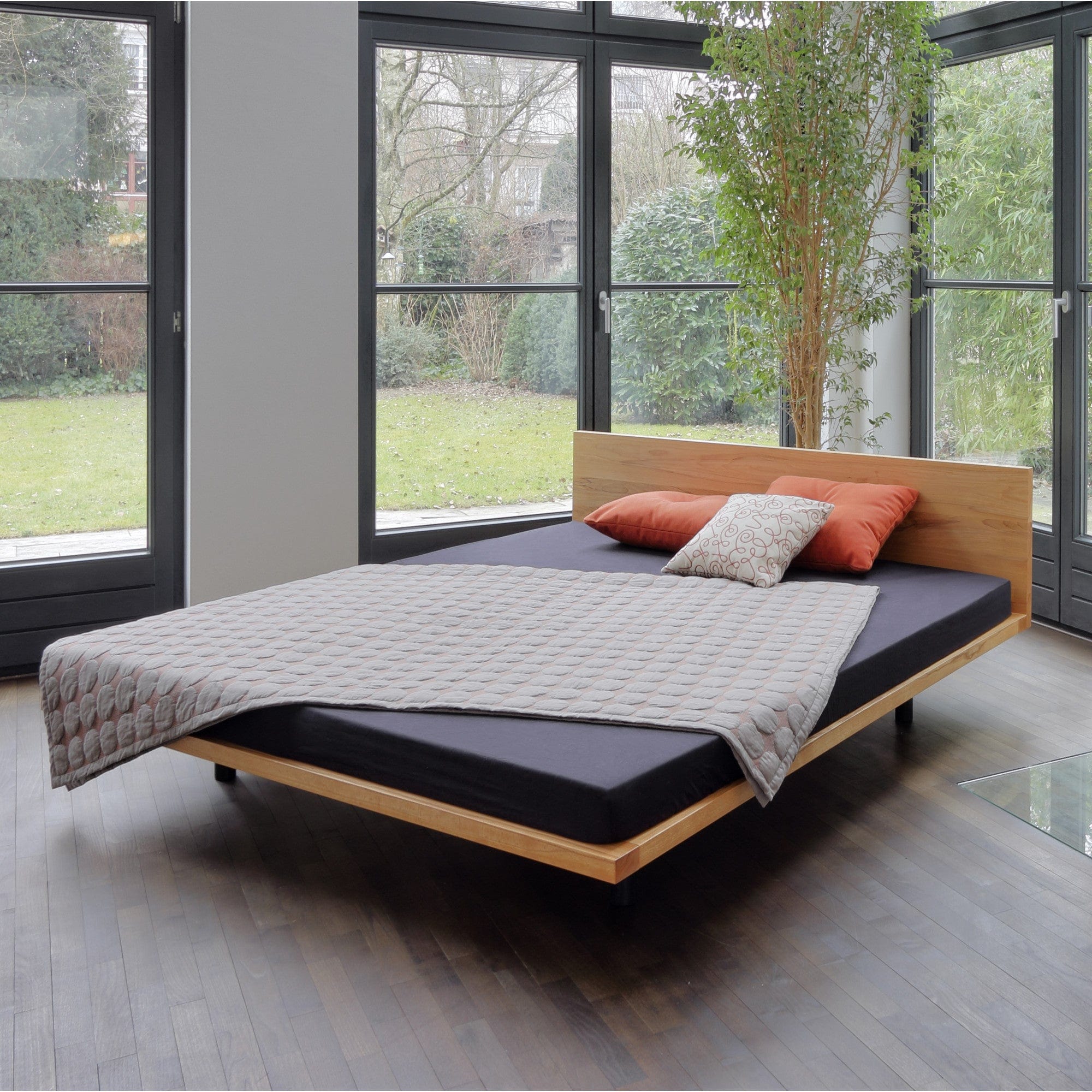 Vollholzbett SWING der Holzmanufaktur: Schwebe-Design Bett für die Dachschräge, 180x200 cm aus Kernbuche mit niedrigem Kopfteil.