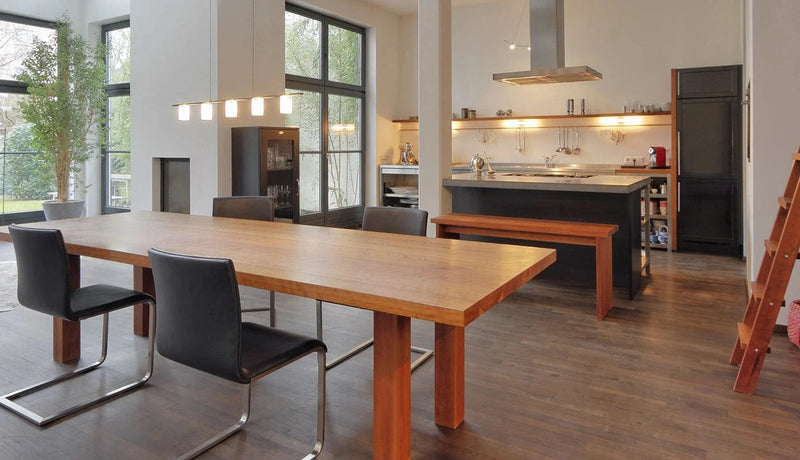 Esszimmer-Tisch vom Schreiner aus massivem Kirschbaumholz mit Stühlen und Regalwand vor offener Wohnküche - gefertigt in unserer Schreinerei Stuttgart