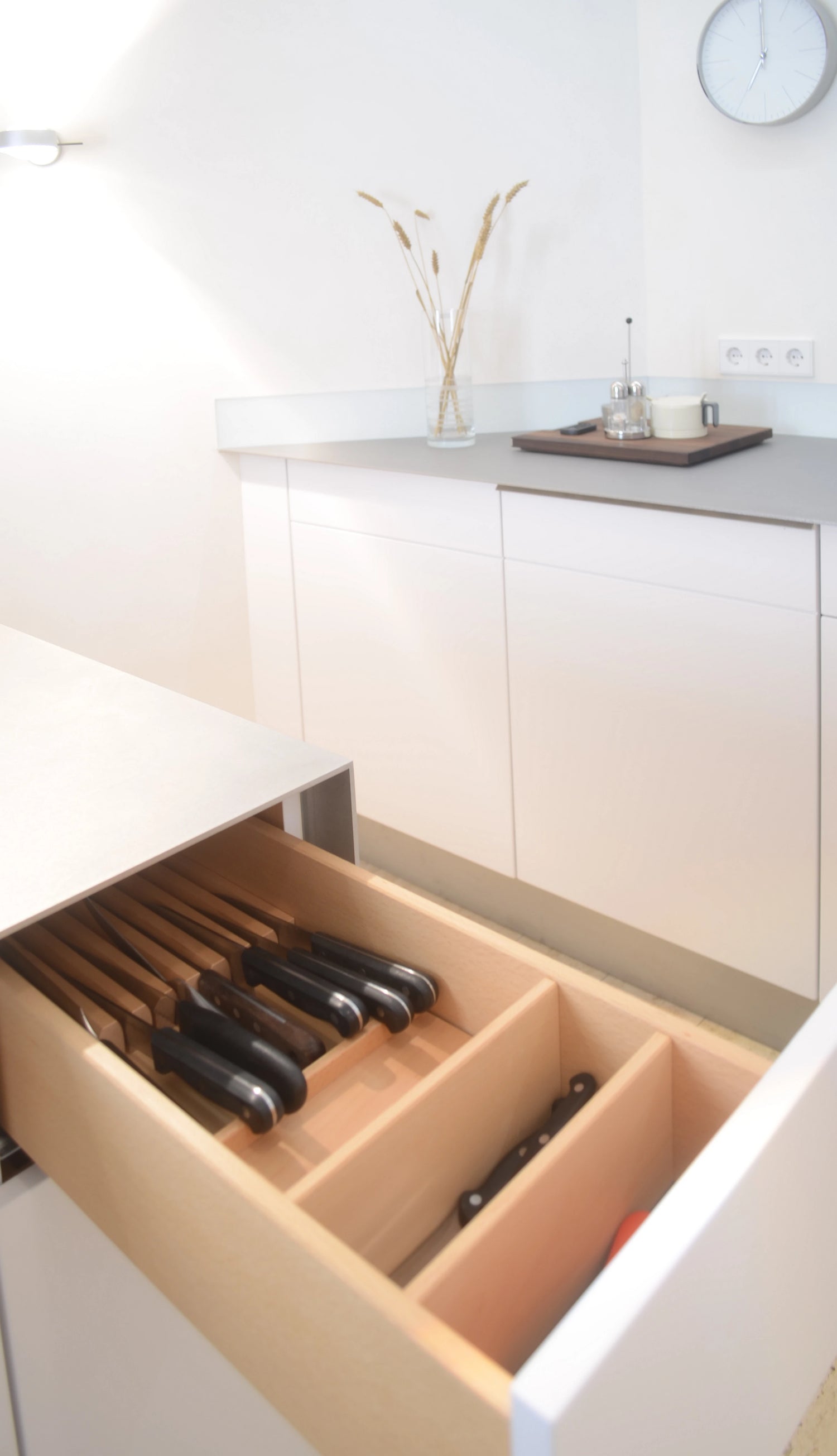 Maßgefertigte Details: Schublade aus Massivholz für Messer in kleiner weißer Küche