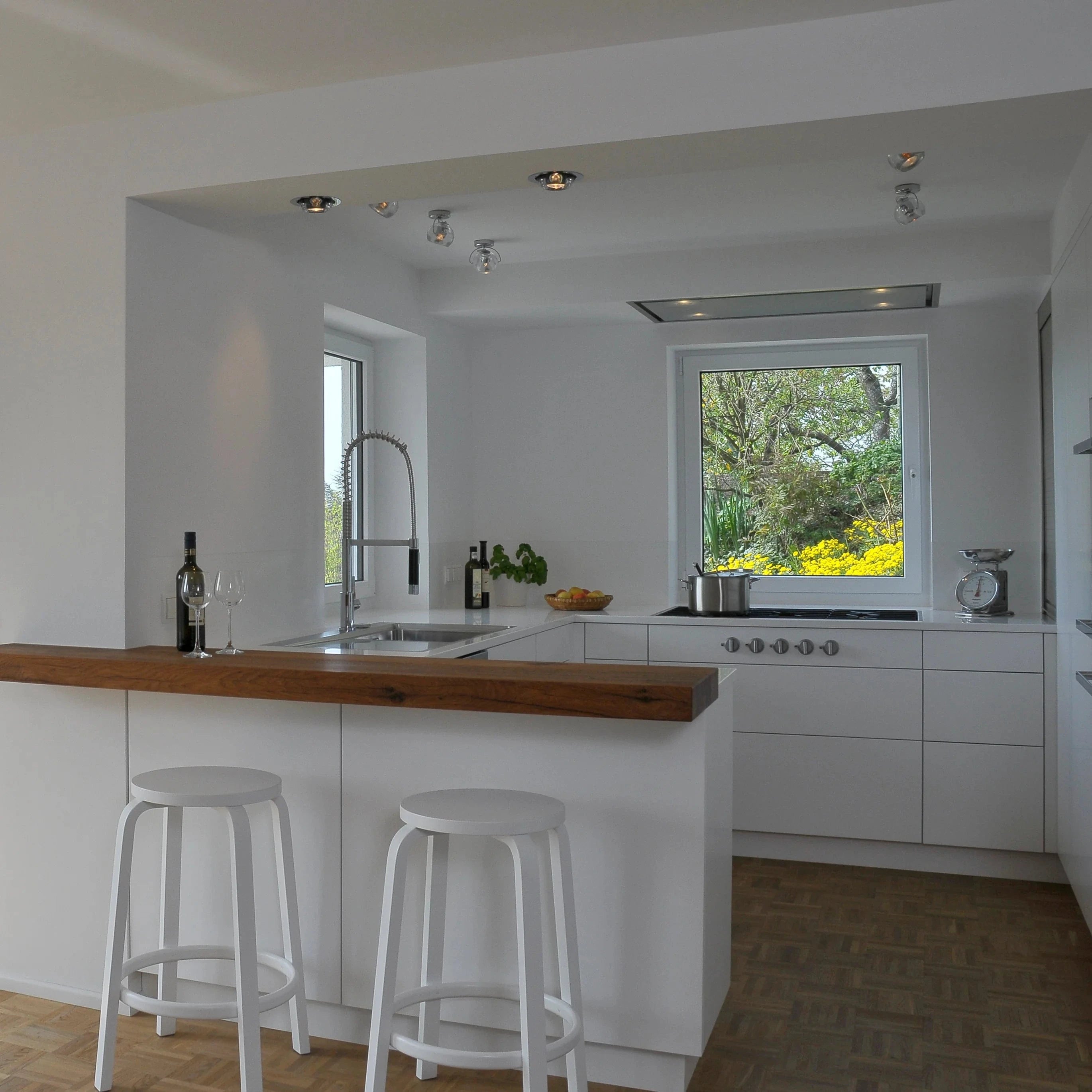 Weiße Küche vom Schreiner mit Thekenplatte aus Eichenholz kombiniert