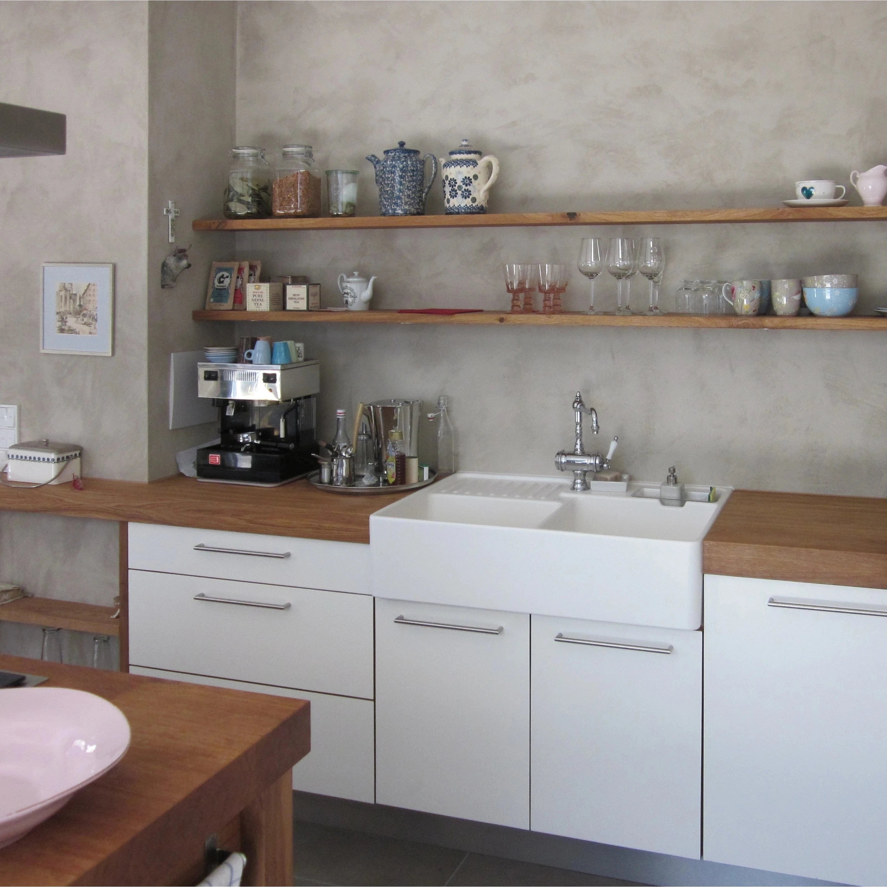 Weiße moderne Landhausküche mit Regalen und Arbeitsplatte aus massivem Buchenholz aus unserer Küchenmanufaktur bei Stuttgart & Ludwigsburg. Originaler, weißer Waschtrog im Landhausstil.