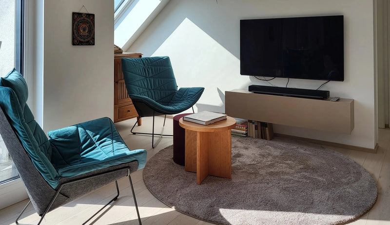 Wohnzimmermöbel vom Schreiner für den Fernsehbereich mit Sideboard, Sesseln und runden Beistelltischen - hochwertiger Innenausbau und Möbelbau von der Schreinerei Holzmanufaktur in der Nähe von Stuttgart.