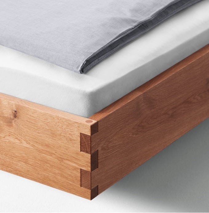 Holzmanufaktur Bett PADIO pur: Ein niedriges Massivholzbett in Wildeiche ohne Kopfteil in der Größe 180x200 cm, metallfrei.