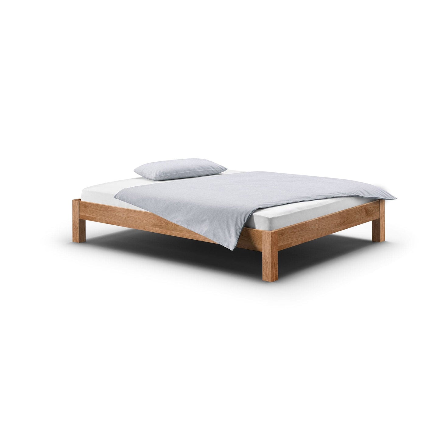 Das niedrige und massive Bett RION aus Eiche ohne Kopfteil passt perfekt unter jede Dachschräge.