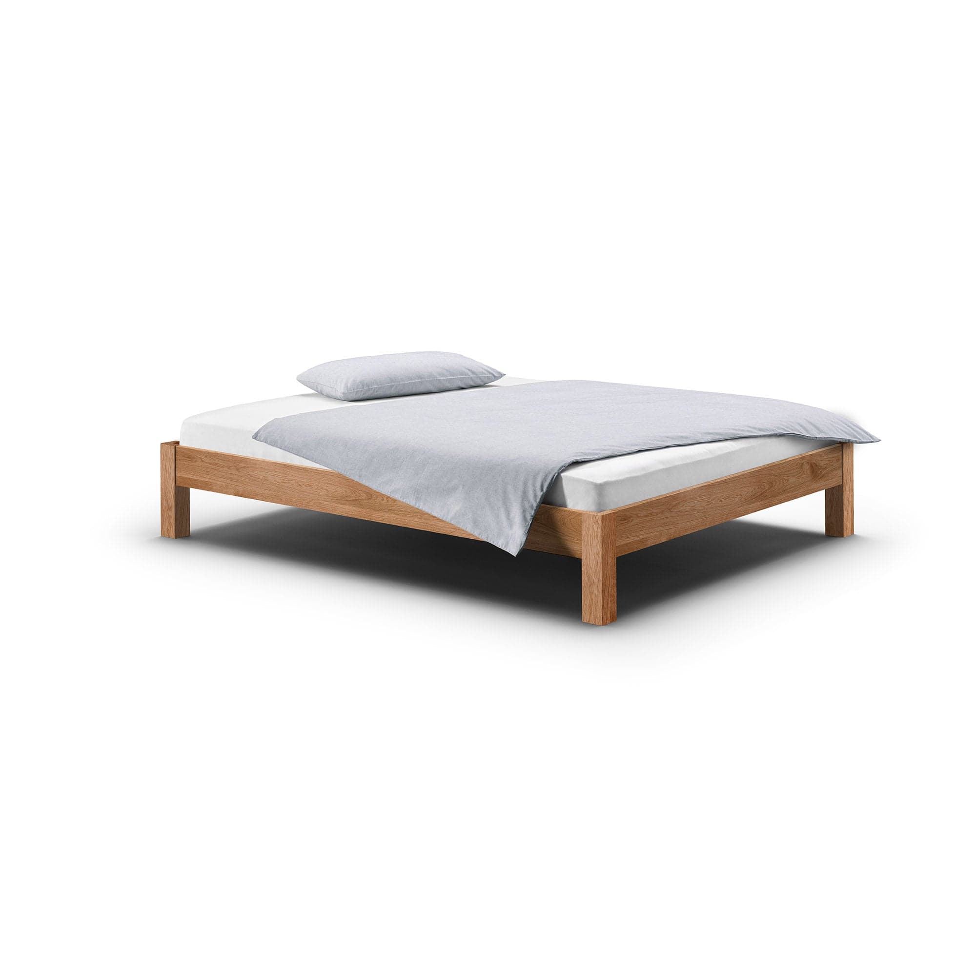 Das niedrige und massive Bett RION aus Eiche ohne Kopfteil passt perfekt unter jede Dachschräge.