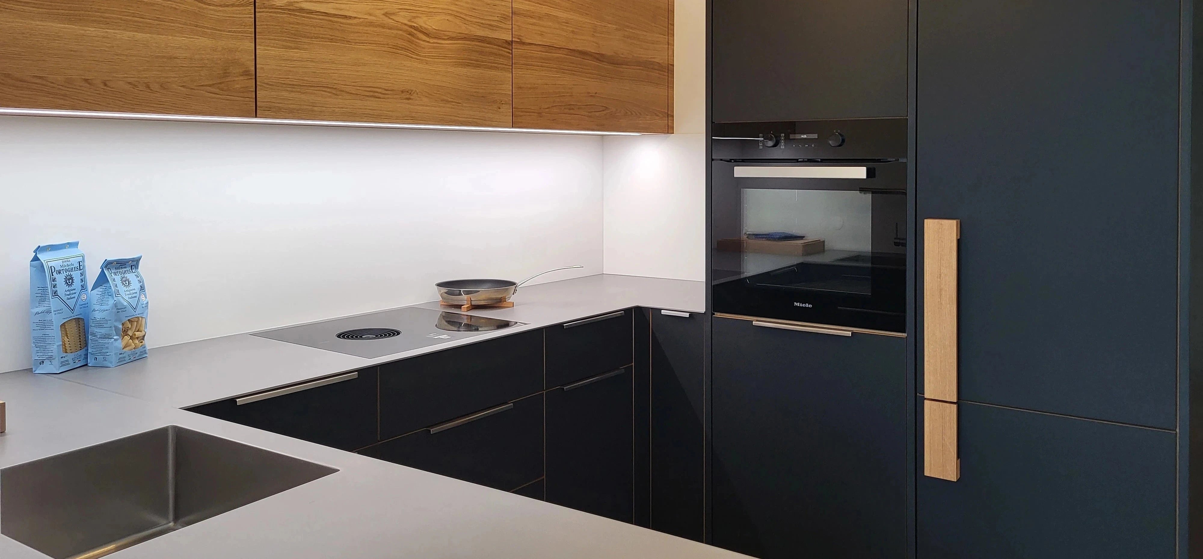 kleine schwarze Küche mit Eiche-Griffelement und Eiche-Oberschränke