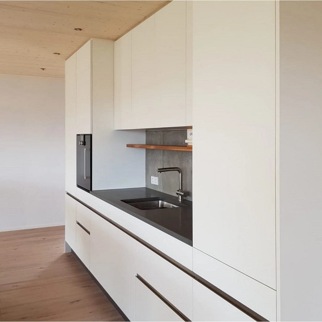 weiße Küche mit Holz und schwarzem Granit kombiniert